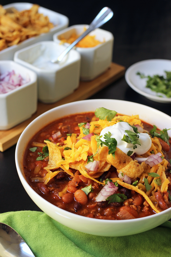 bowl of chili with toppings on side