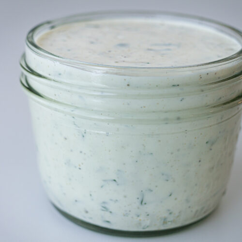 mason jar filled with creamy garlic dressing.