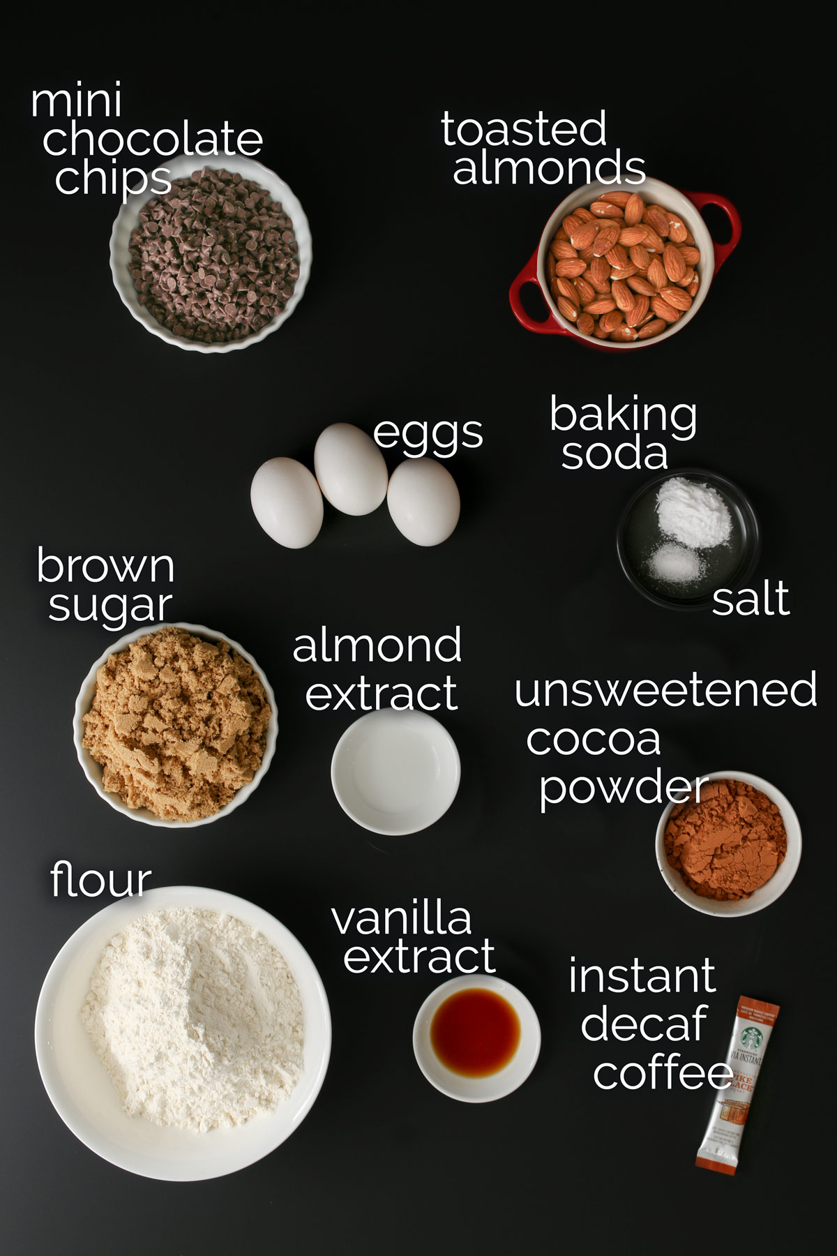 ingredients for chocolate biscotti laid out on a black table top.