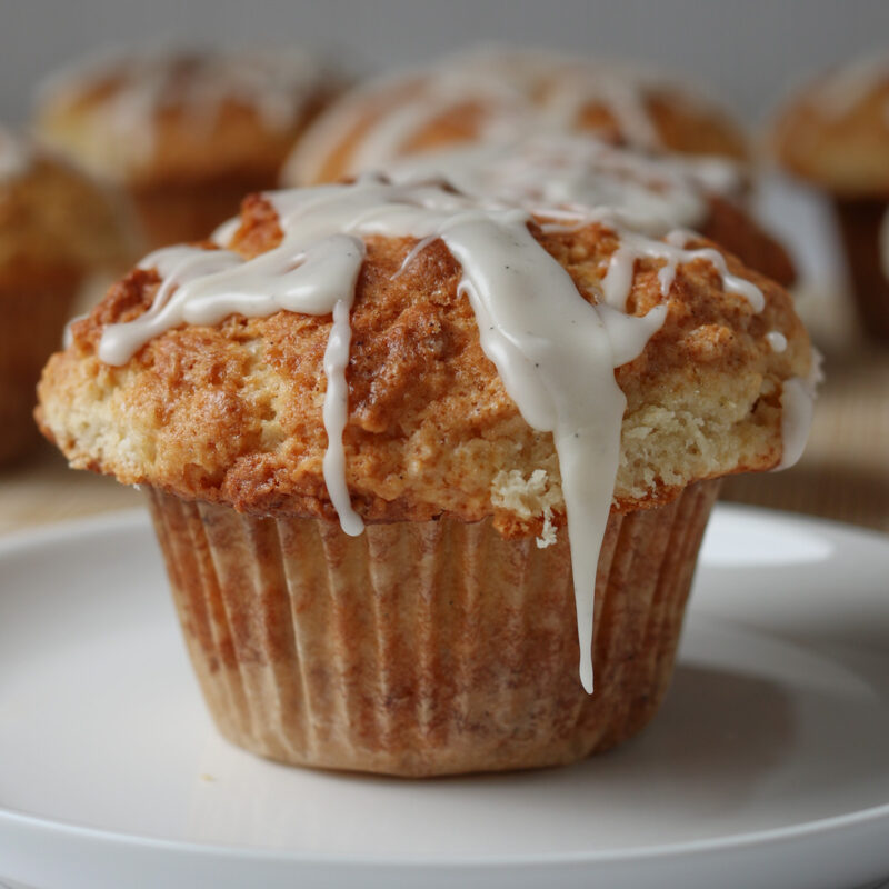glazed muffin on a small plate with more in the background.