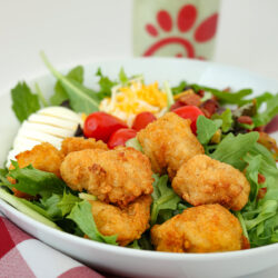 chick-fil-a cobb salad with a red check napkin and bottle of dressing in the background.