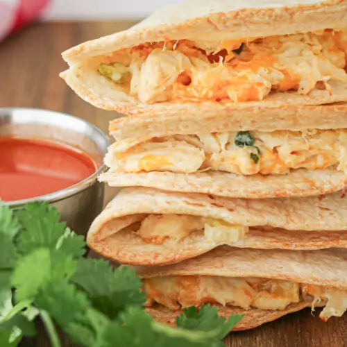 side view of buffalo chicken quesadillas with filling coming out of sides.